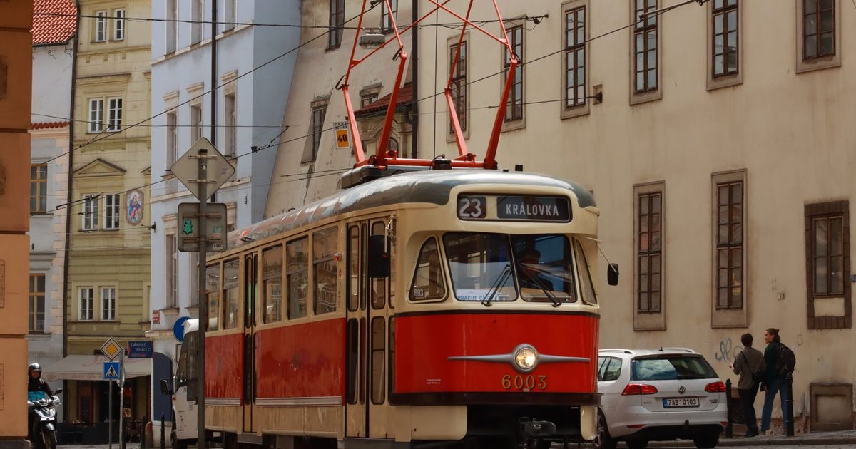 A classic red tram on a street in Prague