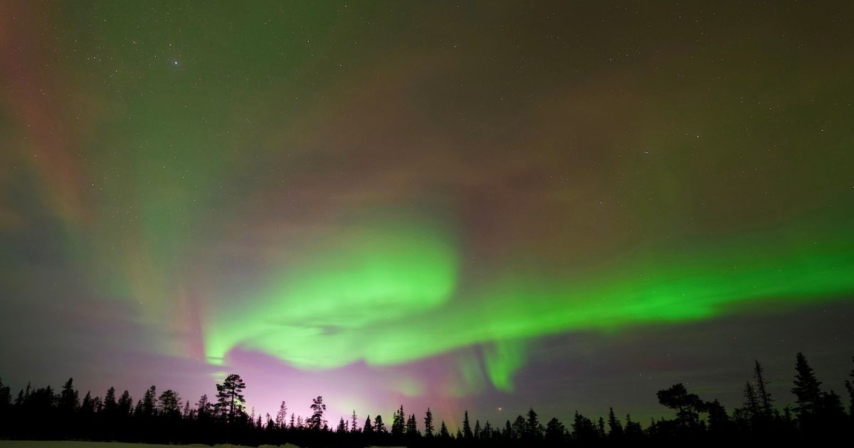 The Northern Lights over a snowy landscape in Kiruna