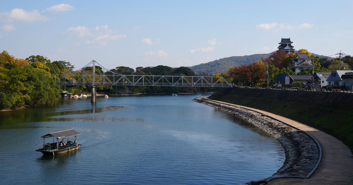 The Asahi River, a bridge and the castle in Okayama, Japan, in autumn